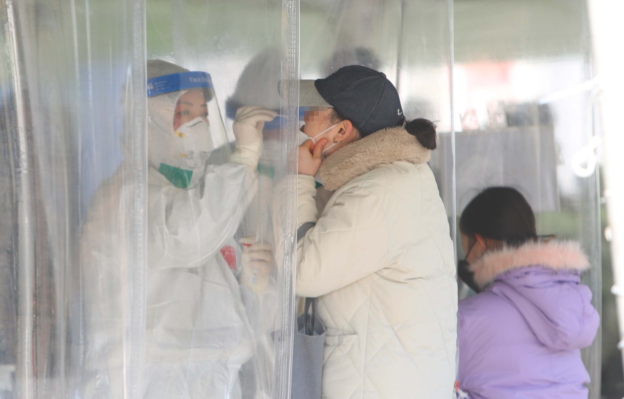 This photo taken Friday, shows a woman taking a coronavirus test at a makeshift testing center in Daegu, 300 kilometers south of Seoul. (Yonhap)