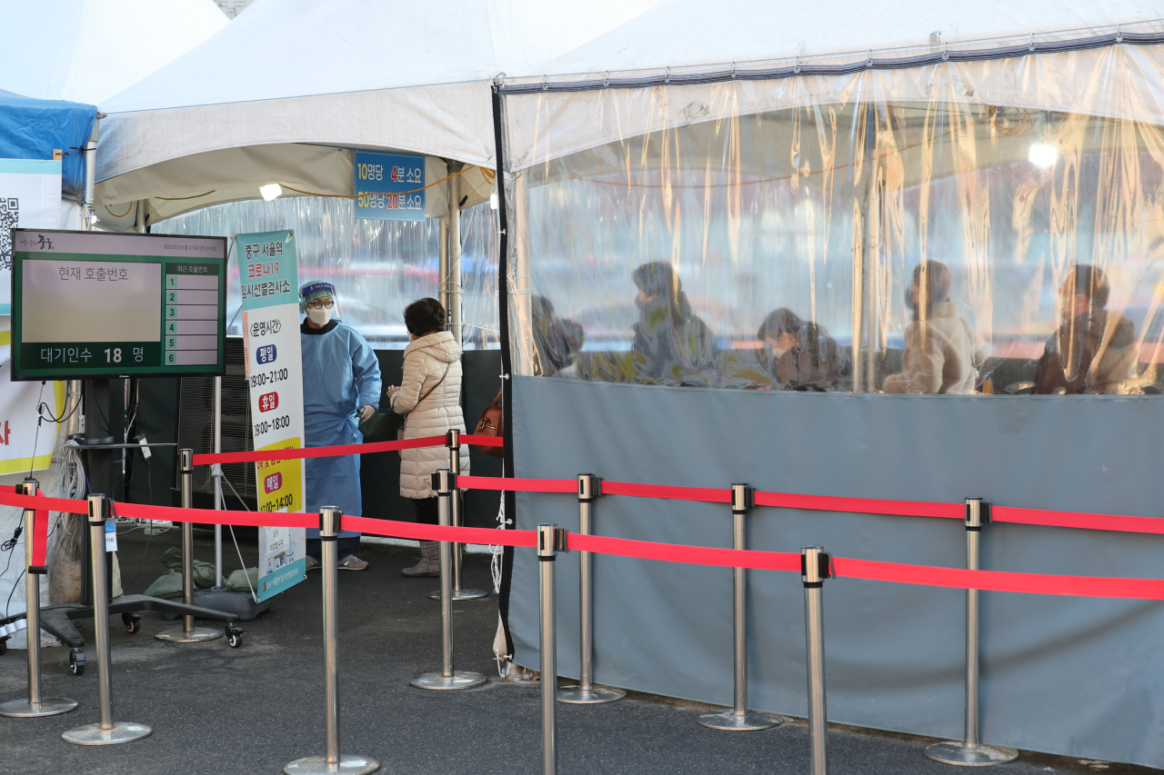 People wait in line for a coronavirus disease test at a testing site in Seoul, Friday. (Yonhap)