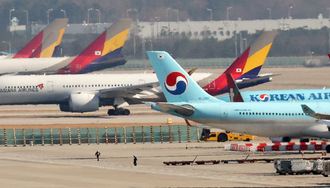 Planes of South Korea's top flag carrier Korean Air Lines Co. and No. 2 carrier Asiana Airlines Inc. are parked at Incheon International Airport, west of Seoul, on Dec. 1, 2020. (Yonhap)