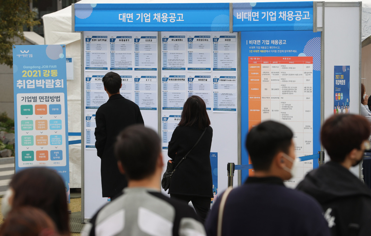 Jobseekers look at an employment information bulletin board at a job fair in eastern Seoul. (Yonhap)