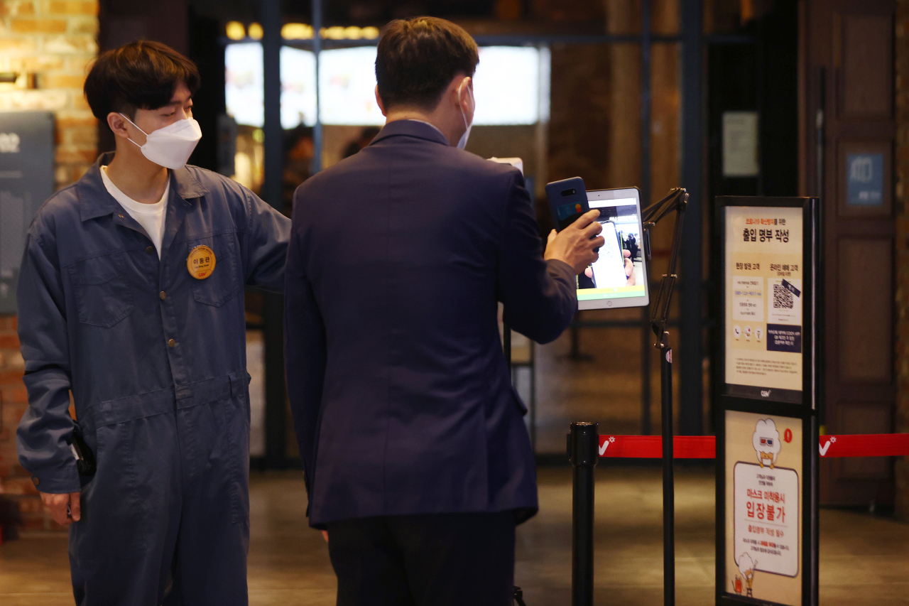 A visitor to a local theater in Seoul check in with a QR code. (Yonhap)