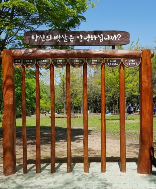 A wooden square frame placed at the Incheon Grand Park with a sign saying “how is your belly doing.” (Kim He-wha.)