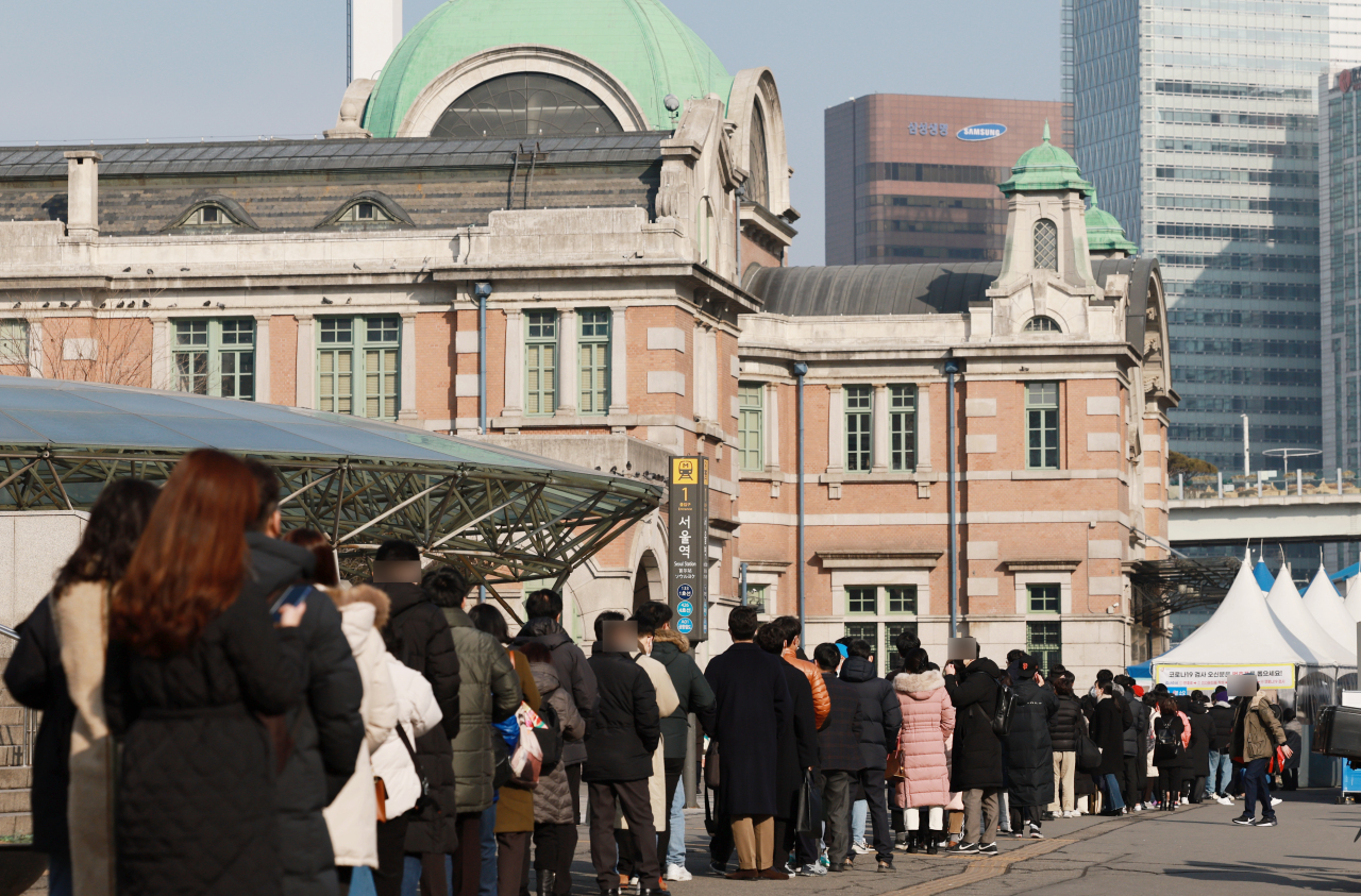 People line up outside a testing clinic near Seoul Station on Thursday. (Yonhap)