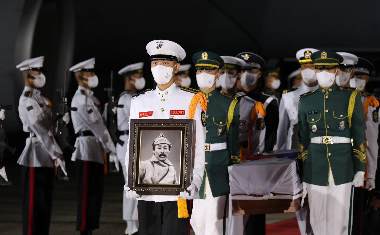 An honor guard of South Korea's military carries a portrait of Hong Beom-do, a historic independence fighter during Japan's colonial rule of Korea, and his coffin at Seoul Air Base in Gyeongi Province on Aug. 15, 2021.