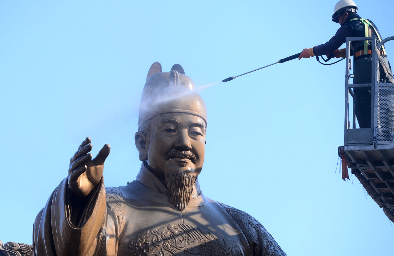 A worker washes the statue of King Sejong in Gwanghwamun in April, 2020.(Lee Sang-sub/The Korea Herald)