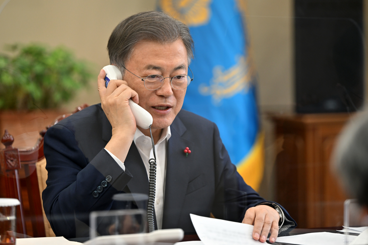 President Moon Jae-in talks with a medical worker over the phone at the presidential office in Seoul last Friday, to encourage such workers struggling with the coronavirus, one day ahead of the Lunar New Year holiday, in this photo provided by the office. (Presidential office)