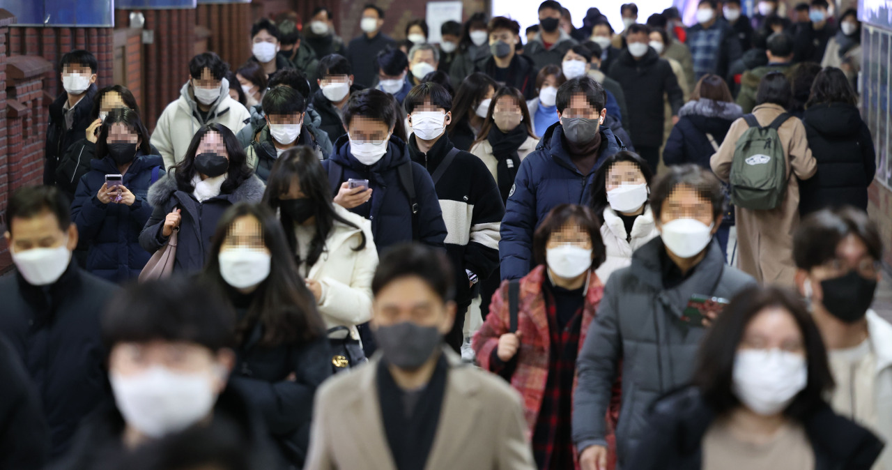 Passengers wearing a mask walk through Seoul Station on Jan. 26. (Yonhap)