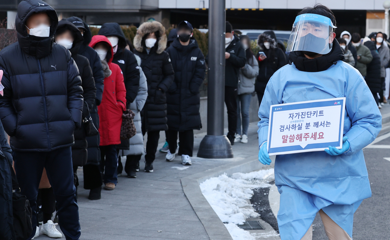 People wait in line to take a COVID-19 test at a testing site in Seoul on Wednesday. (Yonhap)