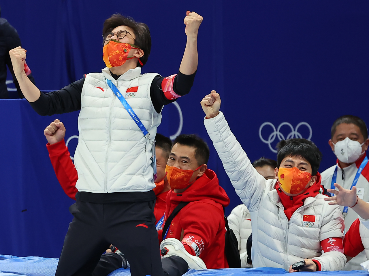 Kim Sun-tae (L) and Victor An (R), the South Korean-born head coach and technical coach of the Chinese national short track speed skating team, celebrate China's gold medal in the mixed team relay at the Beijing Winter Olympics at Capital Indoor Stadium in Beijing on Saturday. (Yonhap)