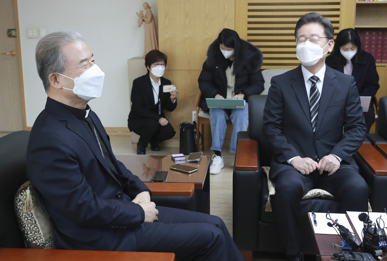 Lee Jae-myung (R), the presidential candidate of the ruling Democratic Party, talks with Matthias Ri Iong-hoon, head of the Catholic Bishops' Conference of Korea (CBCK) in Seoul, during a visit to the CBCK on Friday. (Yonhap)