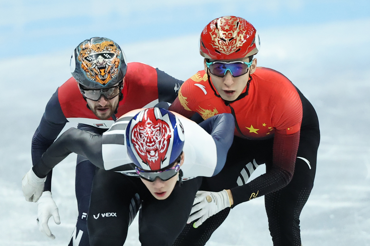 Lee June-seo of South Korea (C) is grabbed by Wu Dajing of China (R) during the semifinals of the men's 1,000m short track speed skating race at the Beijing Winter Olympics at Capital Indoor Stadium in Beijing on Monday. (Yonhap)