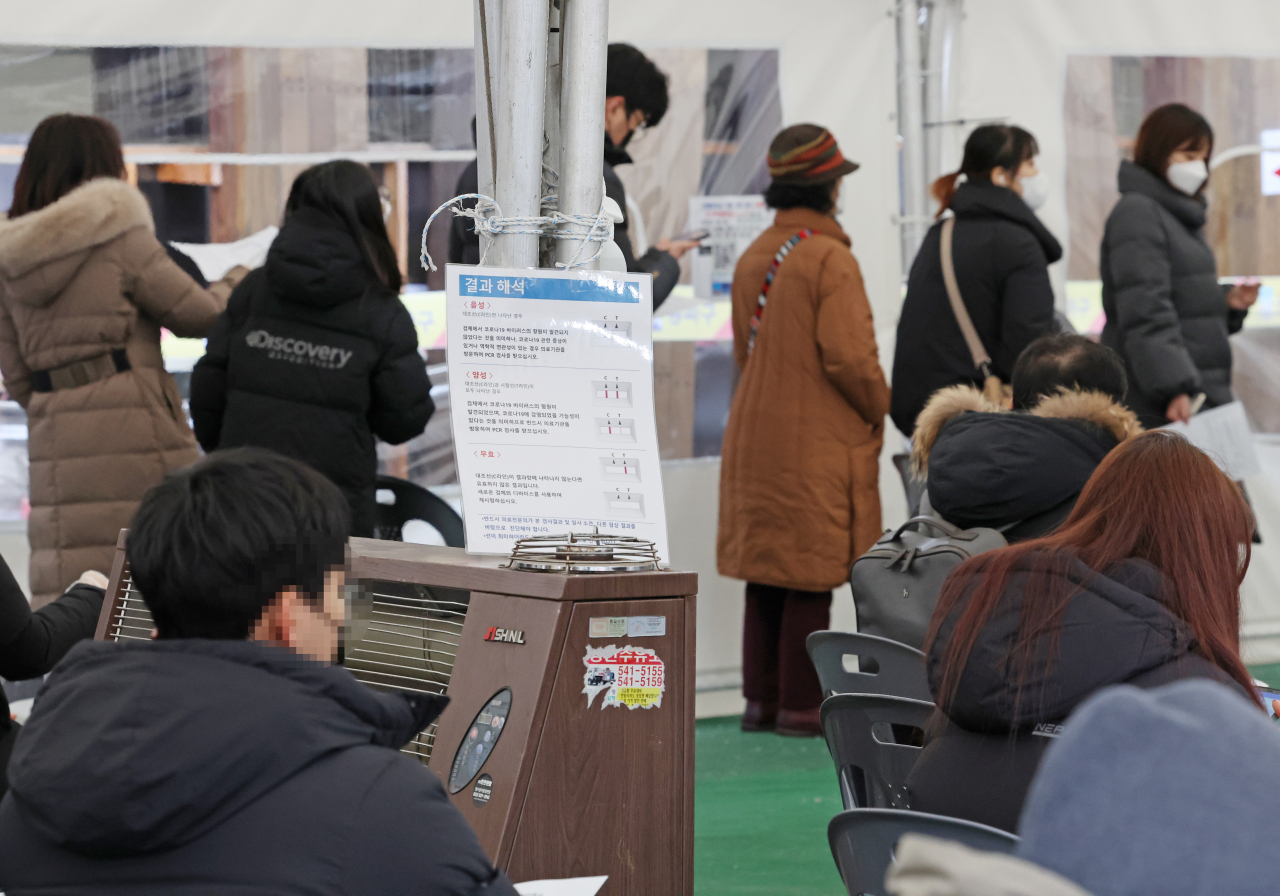 People wait in line to get tested for the coronavirus in Songpa, eastern Seoul, on Monday. (Yonhap)