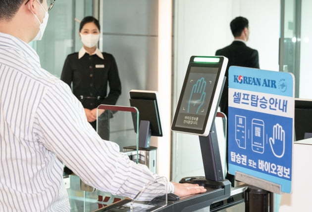 A Korean Air passenger scans his palm at a boarding gate. (Korean Air)
