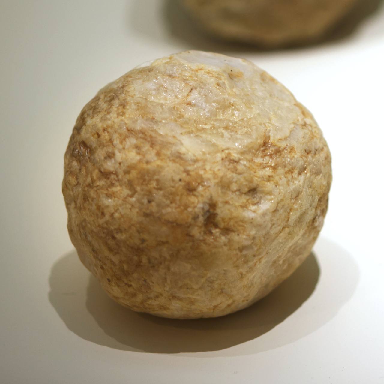 A baseball-sized highly weathered and used hammer stone, used to make handaxe by chipping the stone, also called a spherical polyhedron-bola, from the Stone Age is on display at the National Museum of Jeonju in Korea. It was discovered in Samgil-ri in Imsil-gun, North Jeolla province. Photo © Hyungwon Kang