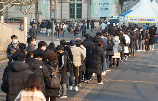 Citizens line up to undergo COVID-19 tests at a makeshift testing station in Seoul on Friday. (Yonhap)