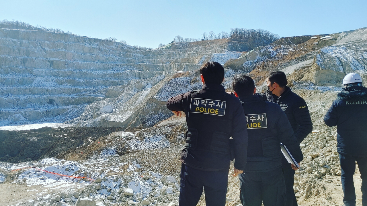 This photo shows police officials investigating a landslide scene at a quarry in Yangju, north of Seoul, operated by Sampyo Industry last Thursday. (Yonhap)
