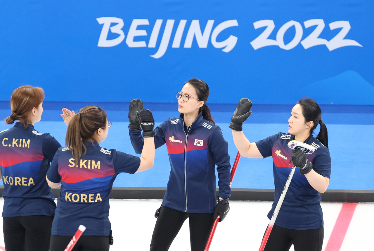 From left to right: South Korean curlers Kim Cho-hi, Kim Seon-yeong, Kim Eun-jung and Kim Kyeong-ae celebrate a point against Britain during their women's curling round robin game at the Beijing Winter Olympics at the National Aquatics Centre in Beijing on Friday. (Yonhap)