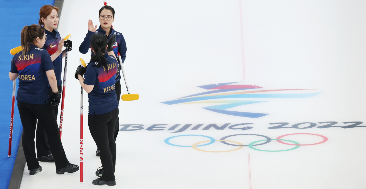 South Korean women's curling team shares high-fives during a match against the Russian Olympic Committee at the National Aquatics Center in Beijing on Saturday. (Yonhap)