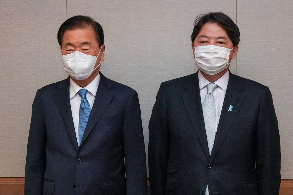 South Korean Foreign Minister Chung Eui-yong (L) and Japanese Foreign Minister Yoshimasa Hayashi are seen posing for a photo during their bilateral meeting in Honolulu last Saturday, in this photo provided by the South Korean foreign ministry. (South Korean foreign ministry)