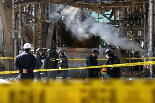 Police officers examine the scene of a factory explosion in the southern city of Yeosu that left four workers dead and four others injured on Friday. (Yonhap)