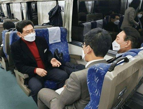 Yoon Suk-yeol (R), the presidential candidate of the main opposition People Power Party (PPP), rests his legs on a train seat in this photo captured from a Facebook page of Lee Sang-il (L), an aide to Yoon, on Sunday. (Facebook page of Lee Sang-il)