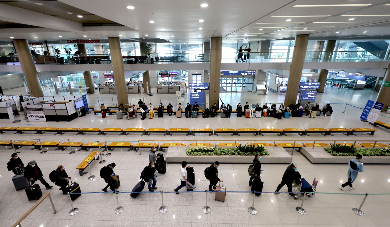 Travelers walk with suitcases at Incheon Airport on Feb. 9. (Yonhap)