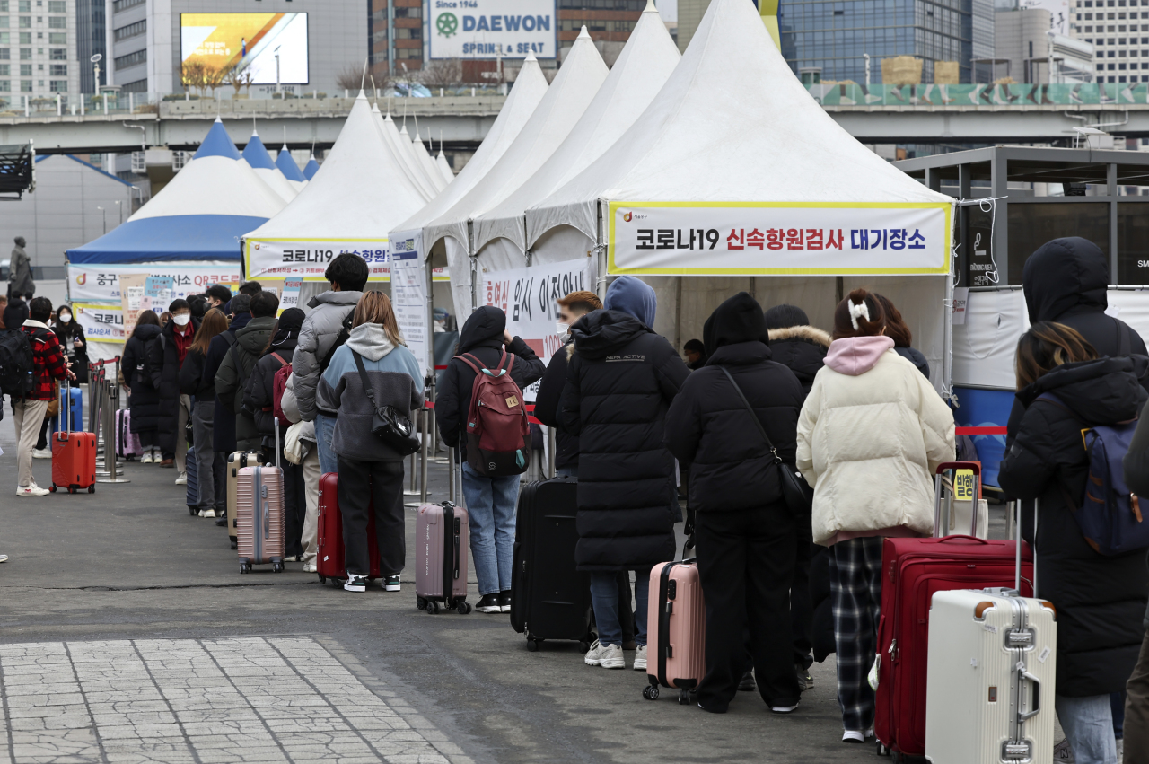 People wait in long lines outside a testing center in Seoul Station to take a rapid antigen test on Monday. (Yonhap)