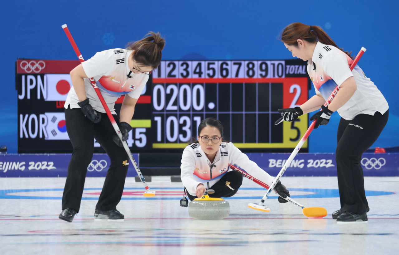South Korean skip Kim Eun-jung (C) delivers a stone during a match against Japan in the women's curling round-robin session at the Beijing Winter Olympics at the National Aquatics Centre on Monday. (Yonhap)