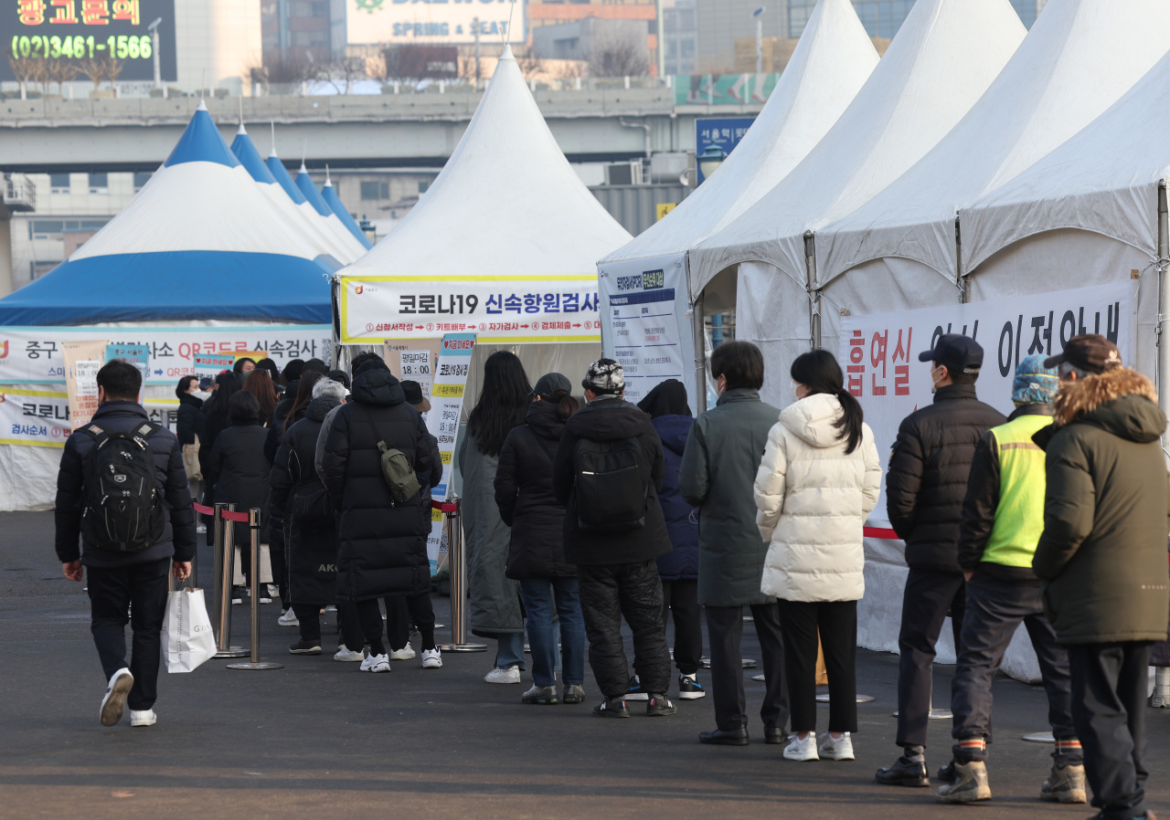 People wait in line to get tested for the coronavirus at a temporary COVID-19 testing center in front of the Seoul railway station last Saturday. (Yonhap)