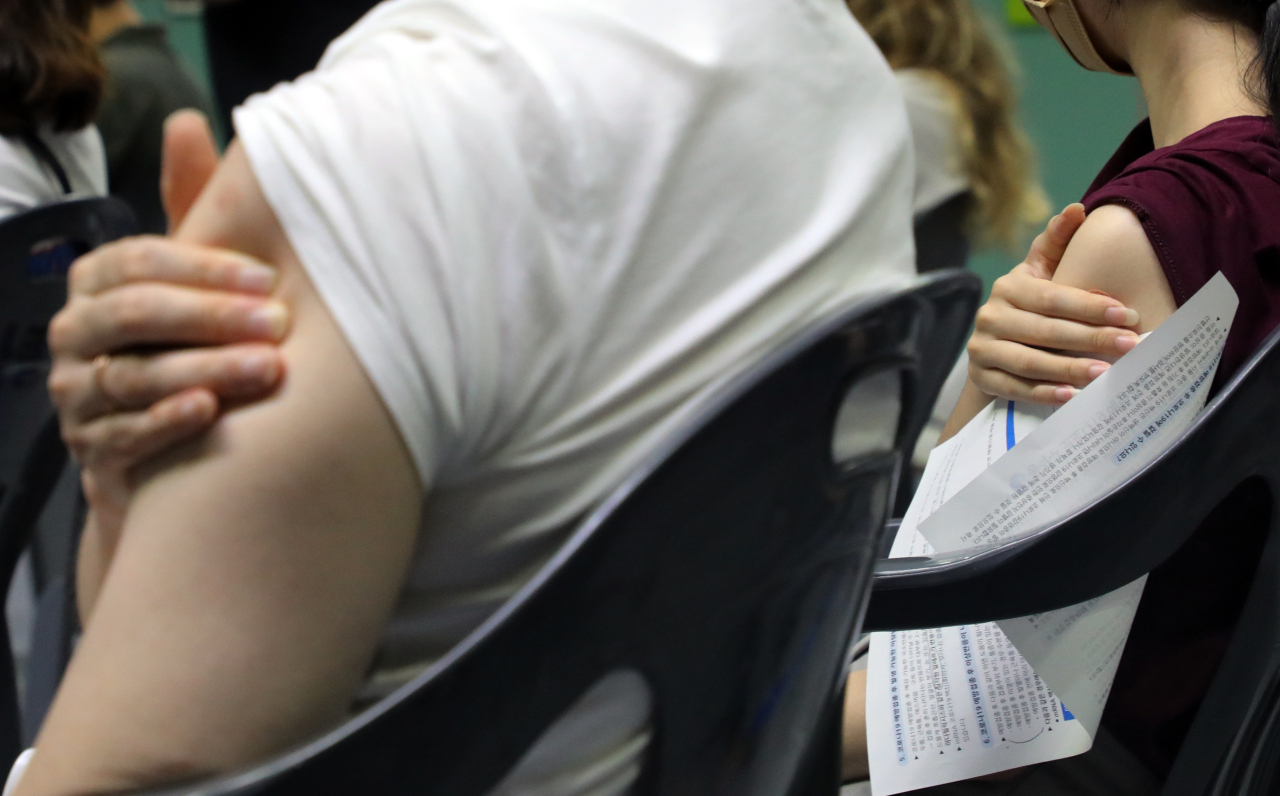 This file photo shows the arms of freshly vaccinated people at a Seoul vaccination clinic. (Yonhap)