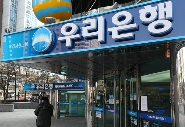 A pedestrian walks past a Woori Bank branch in Seoul (Yonhap)