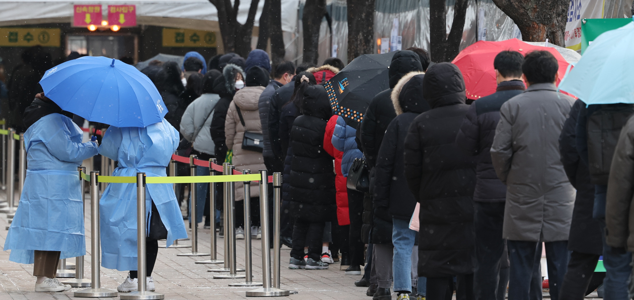 People line up for COVID-19 tests at a testing facility in central Seoul, Tuesday. (Yonhap)