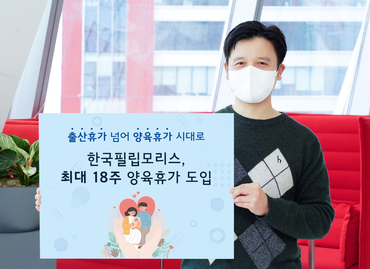 A Philip Morris Korea employee holds up a sign that reads the company has implemented a new parent leave policy to allow up to 18 weeks of parental leave. (Philip Morris Korea)