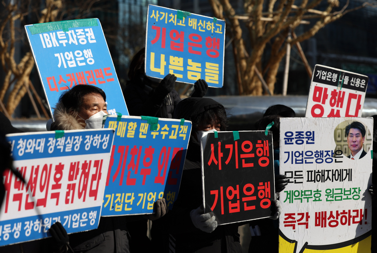 Victims of the troubled Discovery funds hold a protest in front of the Industrial Bank of Korea headquarters in Seoul on Wednesday, asking the lender for 100 percent compensation of the money they lost. (Yonhap)