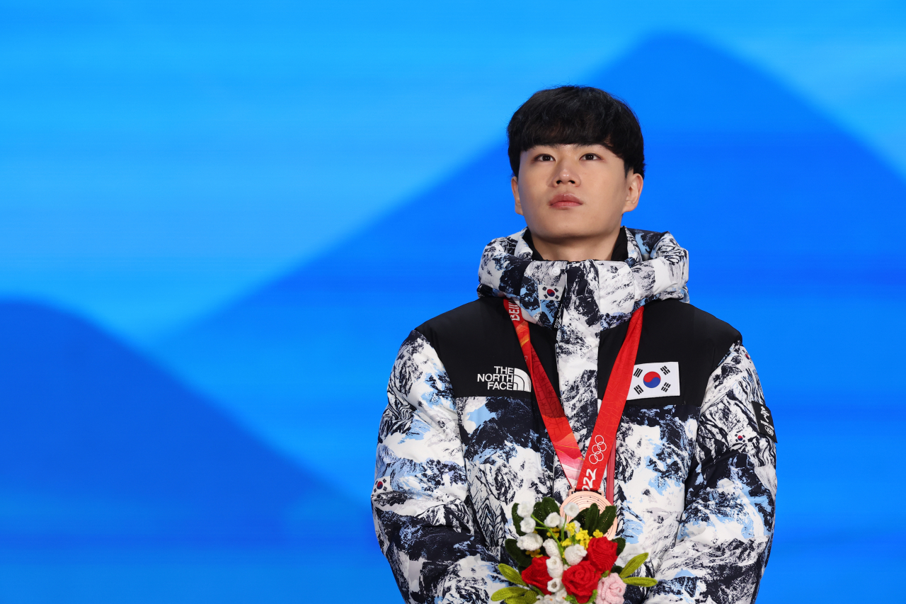 South Korean speed skater Kim Min-seok stands on the podium with his bronze medal from the men's 1,500m race at the Beijing Winter Olympics during the medal ceremony at Beijing Medal Plaza in Beijing last Wednesday. (Yonhap)