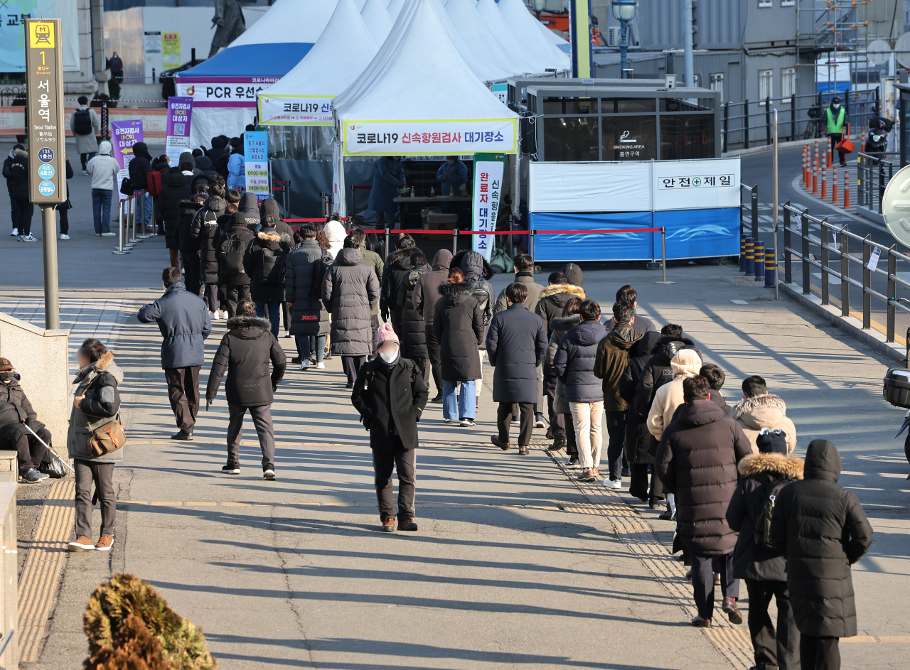 People wait in line to receive tests at a COVID-19 testing station in Seoul on Thursday. (Yonhap)