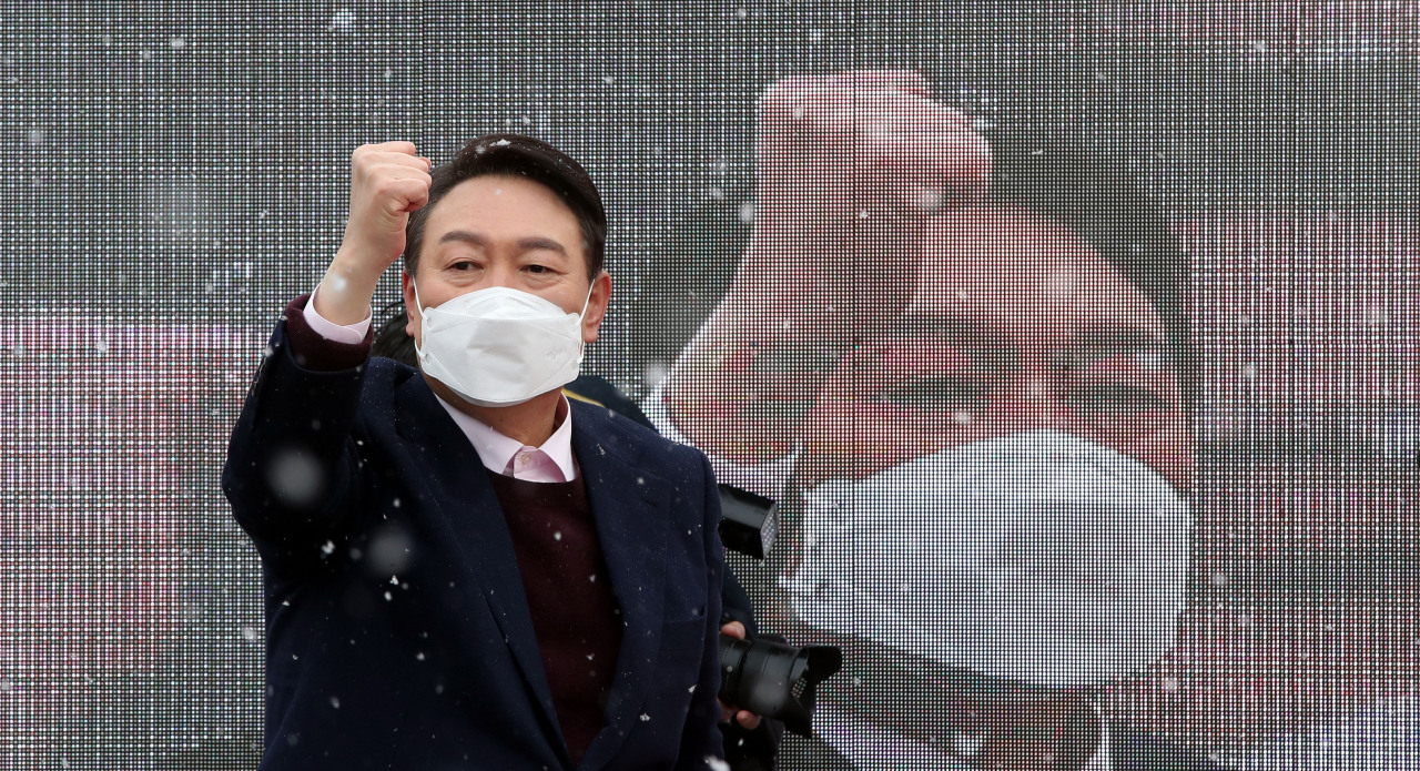 Presidential candidate Yoon Suk-yeol of the main opposition People Power Party holds up a fist during a campaign event in front of Gwangju’s Songjeong Station Market on Wednesday. (Yonhap)