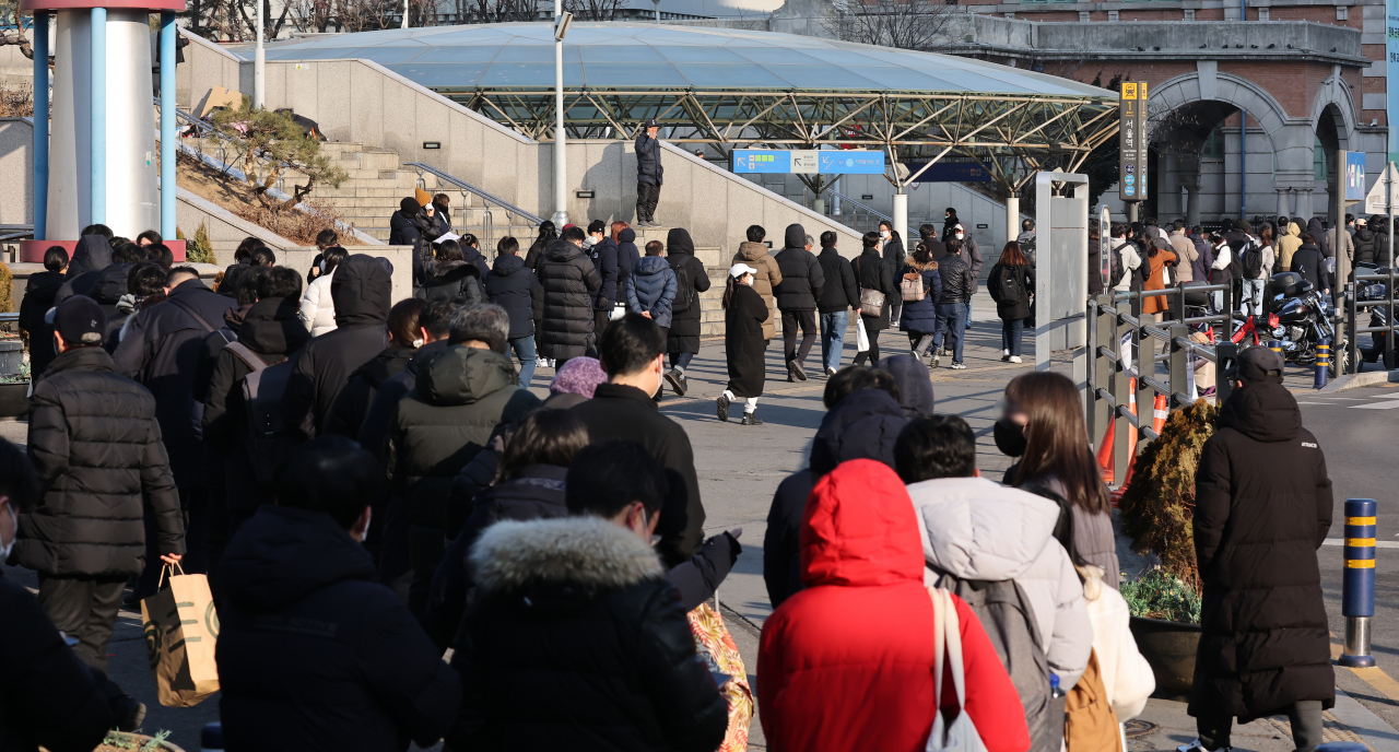 People wait in line to receive tests at a COVID-19 testing station in Seoul today, when the country reported 95,362 new cases. (Yonhap)