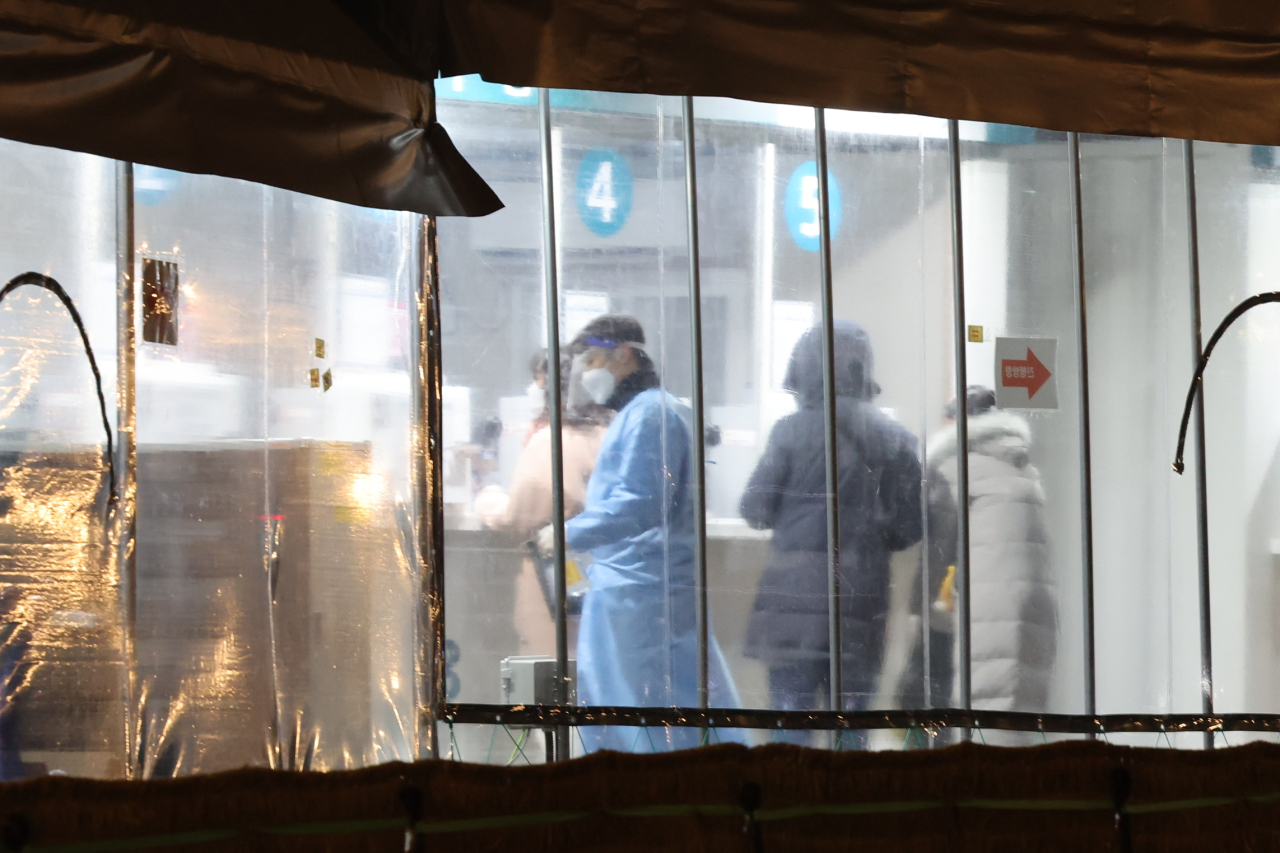 Healthcare workers are seen at a COVID-19 testing center in Seoul, Tuesday. (Yonhap)