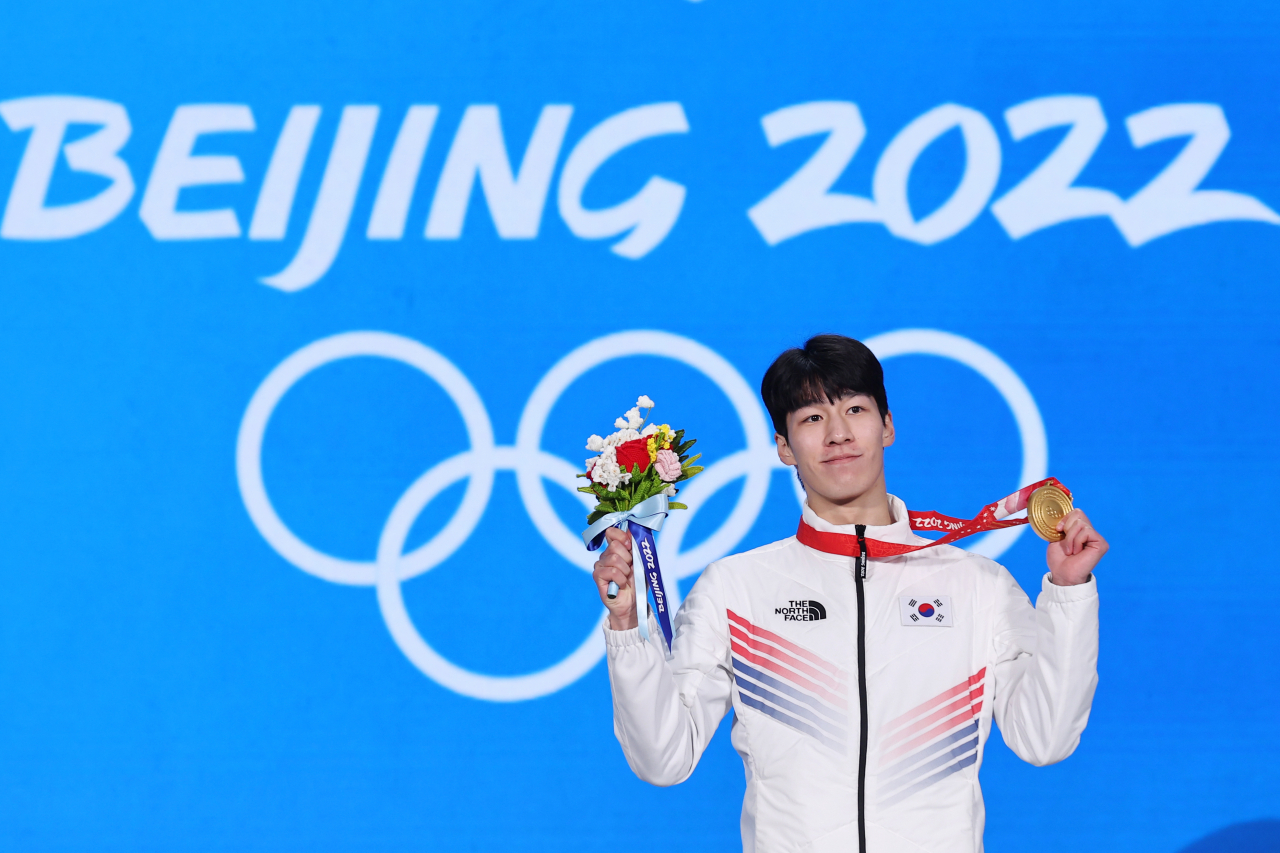 Hwang Dae-heon of South Korea holds up his gold medal from the men's 1,500m short track speed skating race at the Beijing Winter Olympics during the medal ceremony at Beijing Medal Plaza in Beijing, in the Feb. 10, 2022, file photo. (Yonhap)