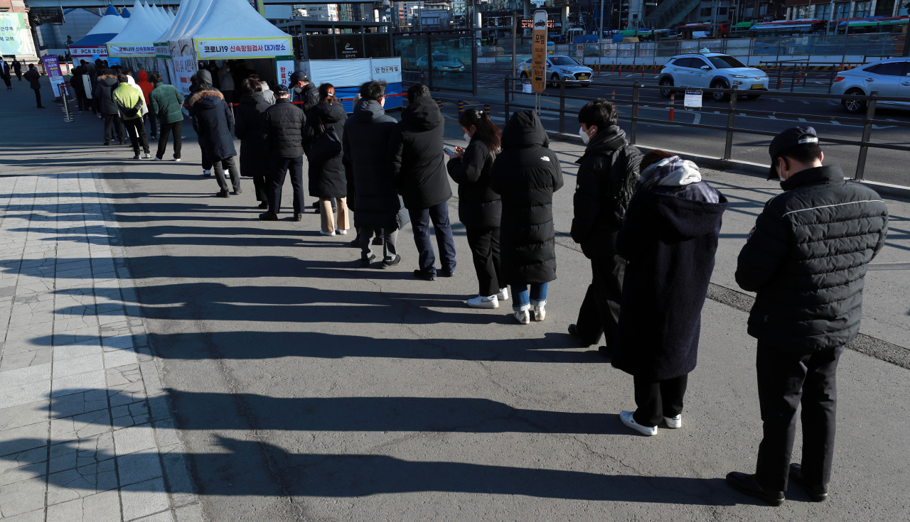 People wait in line to be tested of COVID-19 at a makeshift testing center in front of Seoul Station, Wednesday. (Yonhap)