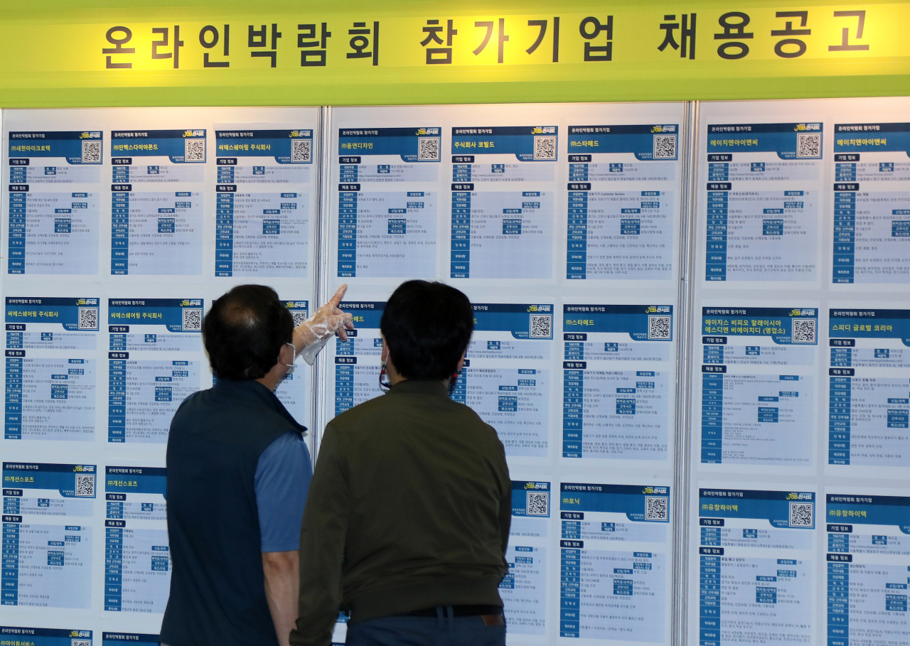 Job seekers look at information at a job fair in Goyang, Gyeonggi Province, on Oct. 7, 2021. (Yonhap)