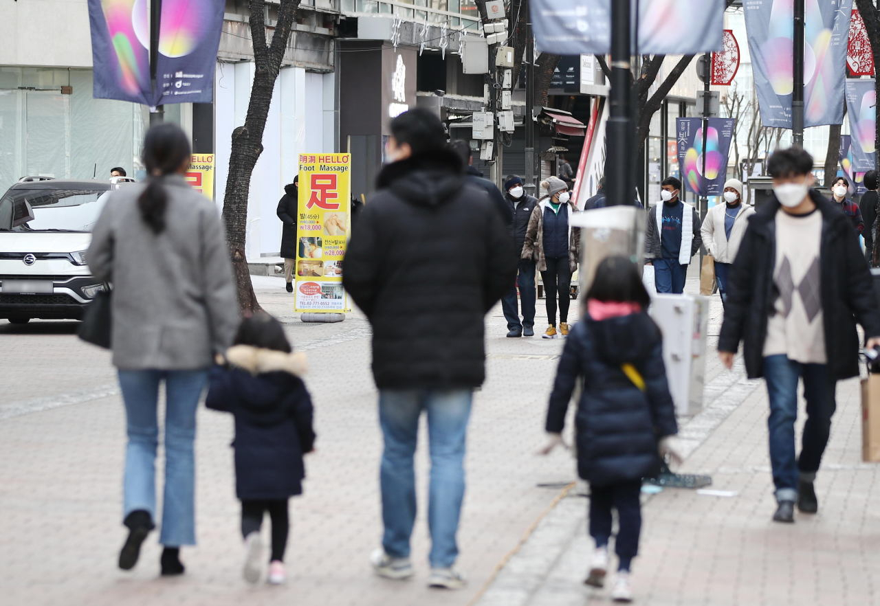 A family strolls through the Myeong-dong shopping district in central Seoul on Jan. 3, 2021. (Yonhap)