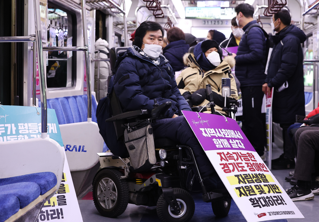Members of the Solidarity against Disability Discrimination stage a protest at Suwon Station on Tuesday.(Yonhap)