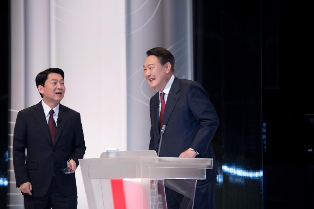 Presidential nominee Ahn Cheol-soo of the minor opposition People`s Party (left) and presidential nominee Yoon Suk-yeol of the main opposition People Power Party (right) speaks before engaging in a TV debate program Friday. (Joint Press Corps)