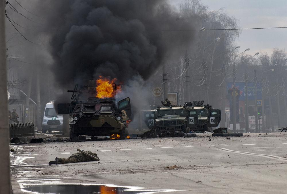 A Russian armored personnel carrier burns amid damaged and abandoned light utility vehicles after fighting in Kharkiv, Ukraine, Sunday. The city authorities said that Ukrainian forces engaged in fighting with Russian troops that entered the country's second-largest city on Sunday. (AP Photo/Marienko Andrew)