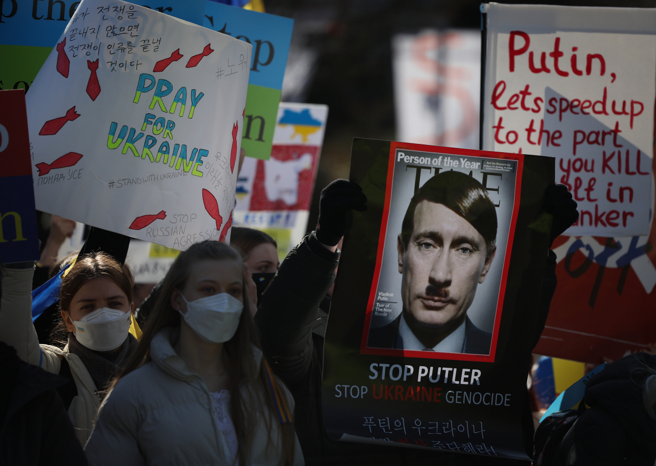 Ukrainian nationals in South Korea and their supporters rally near the Russian Embassy in Seoul on Sunday, to protest against Russia's invasion of Ukraine. (Yonhap)