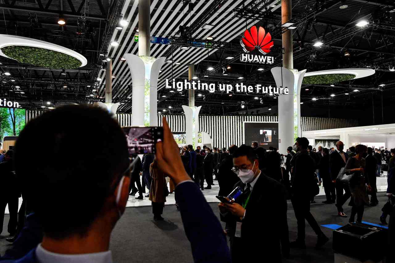 Visitors take pictures of the Huawei booth at the opening day of the Mobile World Congress in Barcelona, Spain, Monday. (AFP-Yonhap)