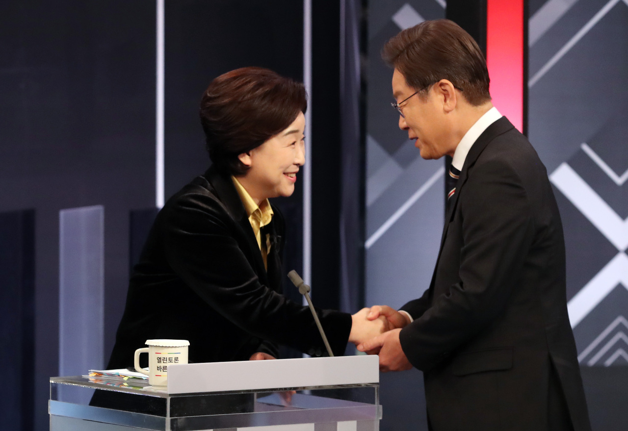 Presidential nominee Lee Jae-myung (right) of the ruling Democratic Party of Korea and Rep. Sim Sang-jung (left), presidential candidate for the minor left-wing Justice Party, shake hands for greeting ahead of participating in a TV debate program Wednesday. (Joint Press Corps)