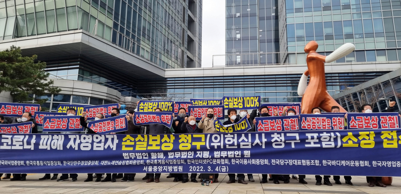 Small business owners hold a press conference in front of the Seoul Administrative Court in southern Seoul on Friday, before filing a damage suit over COVID-19 business restrictions. (Yonhap)